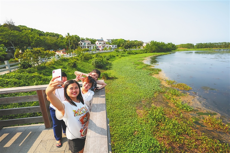 游客在博鰲沙美村的美景前合影留念