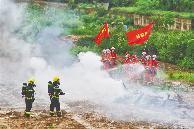 在演練現(xiàn)場，撲火隊員在對“森林火災(zāi)”進(jìn)行撲救