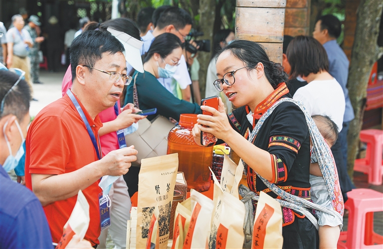 毛納村村民在向游客介紹當(dāng)?shù)氐奶厣a(chǎn)品