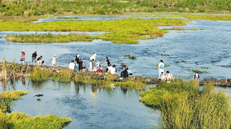 遵譚昌旺溪畔，市民游客沿著溪流漫步